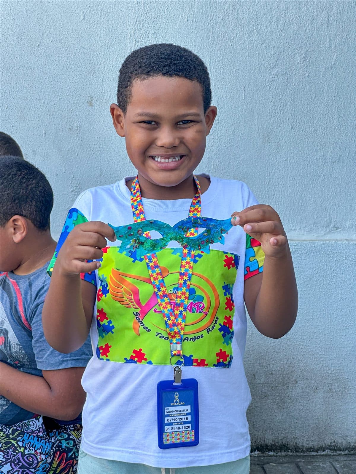 Criança da ONG STAR sorrindo com máscara que ela mesma confeccionou