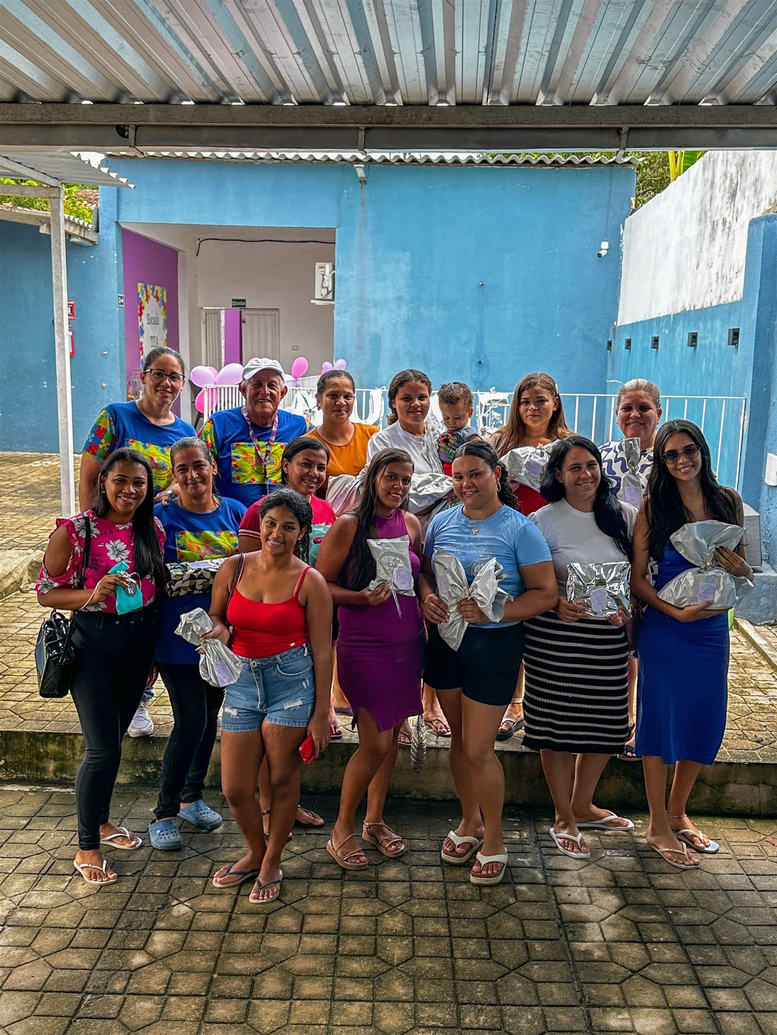 Famílias atendidas pela ONG STAR reunidas com lembranças recebidas